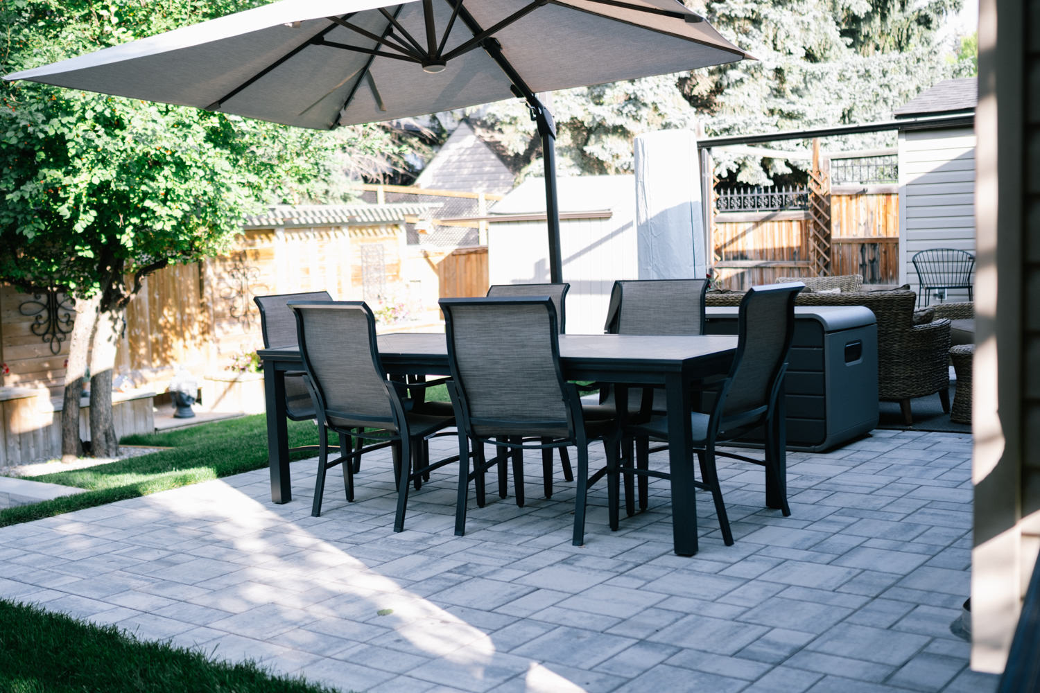 Stone patio with seating area in a Tower Hill backyard in Okotoks