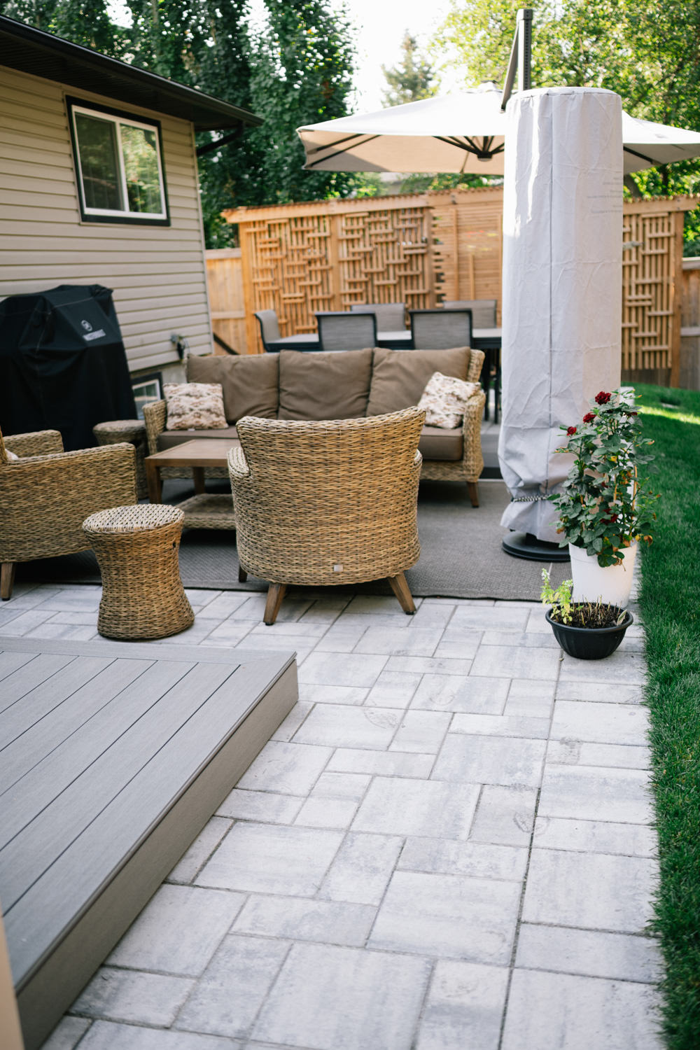 Stone patio with seating area in a Tower Hill backyard in OkotoksThis Tower Hill backyard in Okotoks features a stone patio with a welcoming seating area, designed by Kayben Landscaping to create a comfortable and stylish outdoor living space.