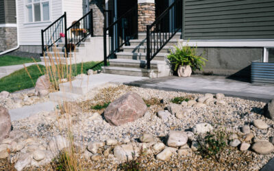 Residential landscaping featuring a stone pathway, decorative rocks, and low-maintenance plants in front of a modern home, showcasing Kayben Landscaping's design expertise in estate homes.