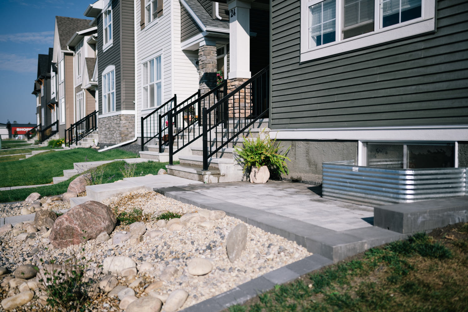 Residential xeriscape front yard featuring stone pathways, decorative boulders, and a planter, showcasing sustainable landscaping in the Wedderburn community.