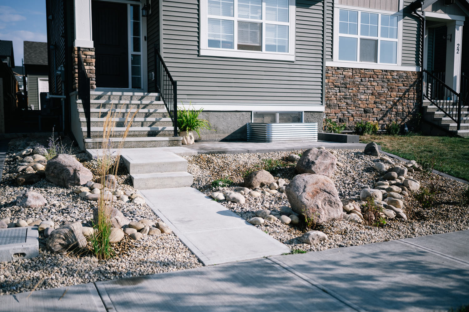 Xeriscaped front yard featuring stone pathways, decorative rocks, and drought-resistant plants, showcasing sustainable landscaping practices by Kayben Landscaping in Wedderburn.