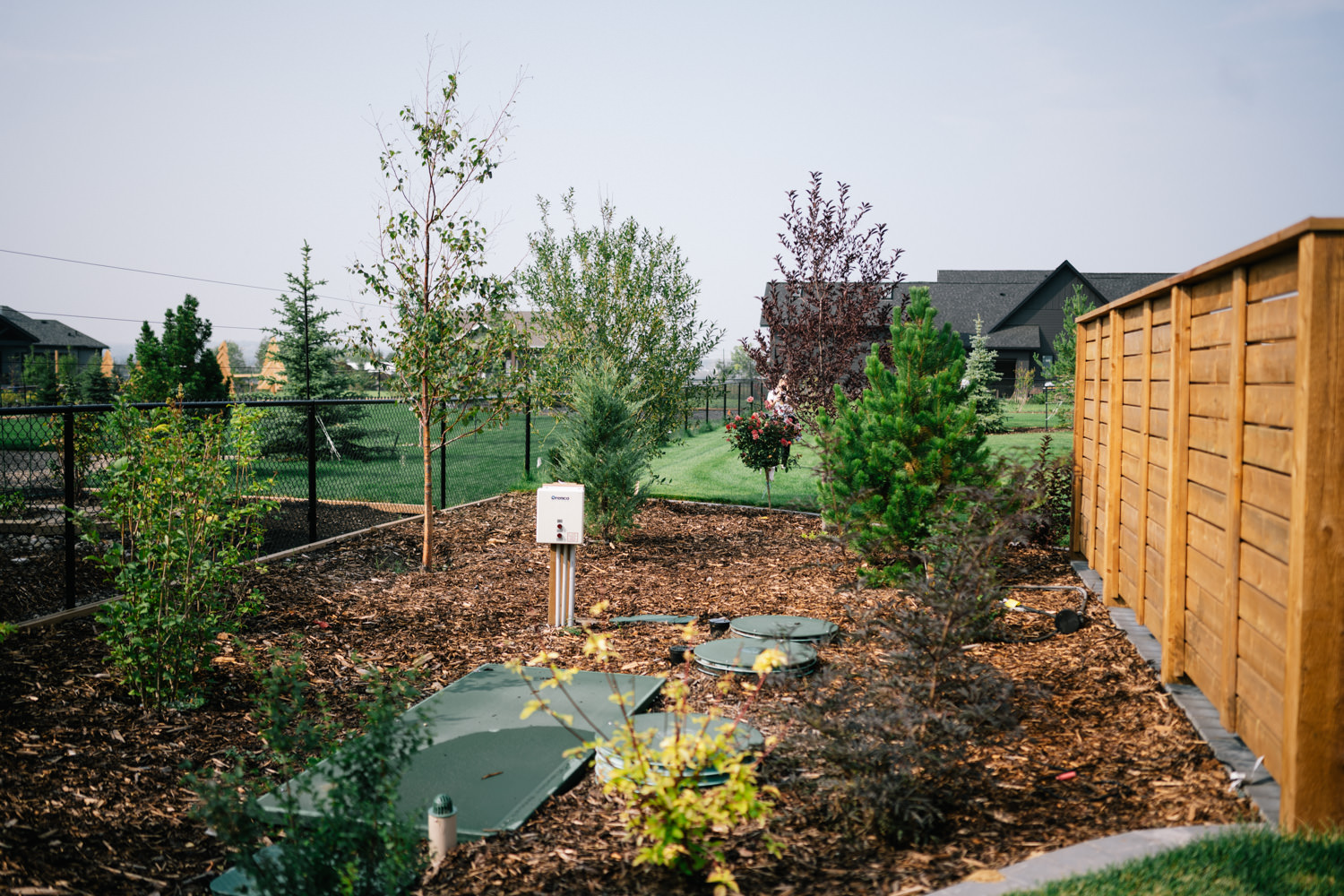 Landscaped yard in Green Haven featuring trees, shrubs, mulch, and a privacy screen fence.