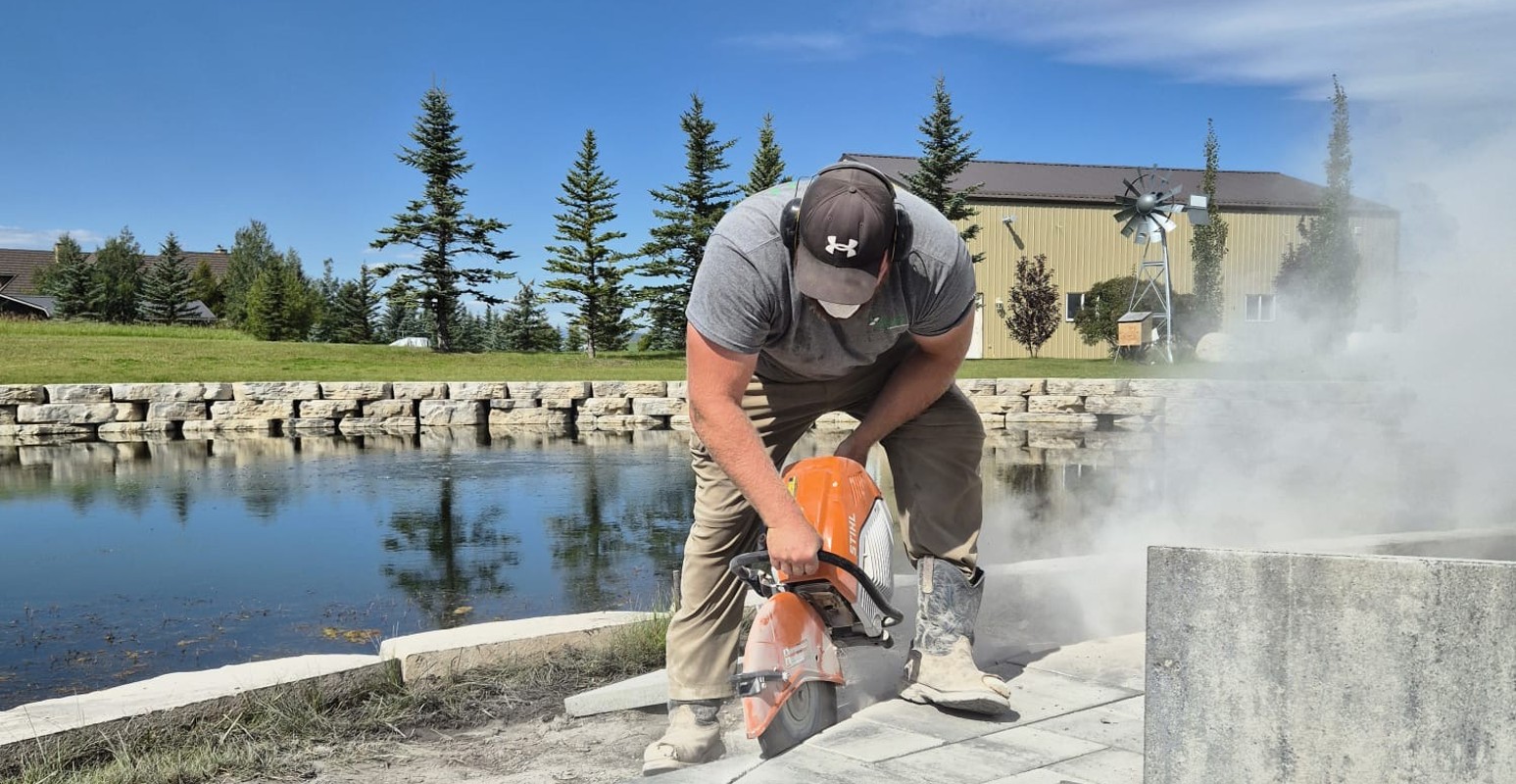 Kayben crew member cutting a patio edge
