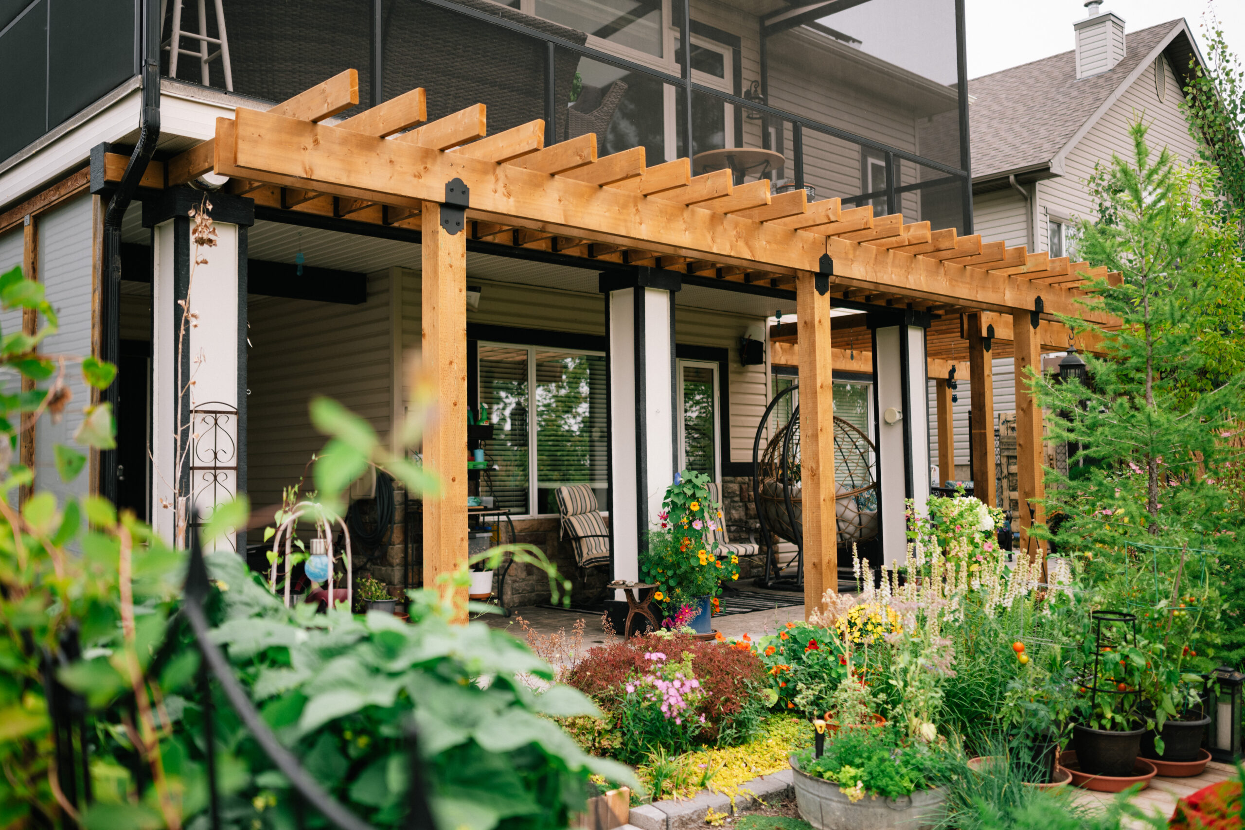 Finished Okotoks residential yard with lawn, planting, and outdoor structure by Kayben Landscaping